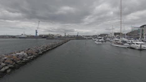 cinematic-fly-through-video-of-a-large-and-fast-push-through-boat-slowly-motoring-down-the-water-during-a-grey-and-overcast-day-by-the-south-coast-of-england