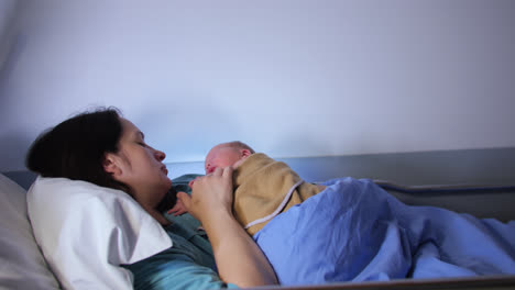 Mother-and-Newborn-Baby-Infant-Lying-In-Bed-In-Childbirth-Clinic-Room