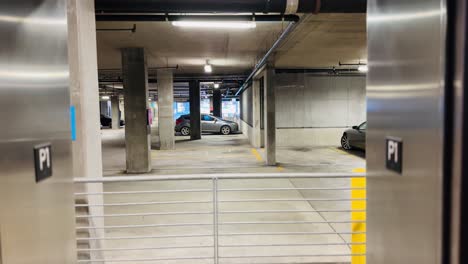 Parking-garage-elevator-door-opens-and-closes,-revealing-and-concealing-the-dimly-lit-interior,-capturing-the-functional-and-utilitarian-aspect-of-urban-infrastructure