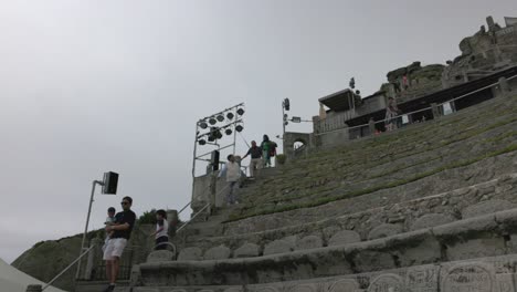 Toma-Inclinada-Del-Teatro-Minack-Construido-En-La-Ladera-De-Un-Acantilado-Con-Turistas