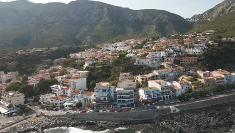 Cala-Gonone,-Golfo-De-Orosei,-Cerdeña,-Italia:-Casas-Vibrantes-Con-Vista-A-La-Playa,-Fotografía-Tomada-Con-Un-Dron-En-órbita