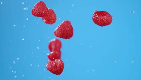 Seven-raspberries-launched-in-air,-flying-and-spinning-with-water