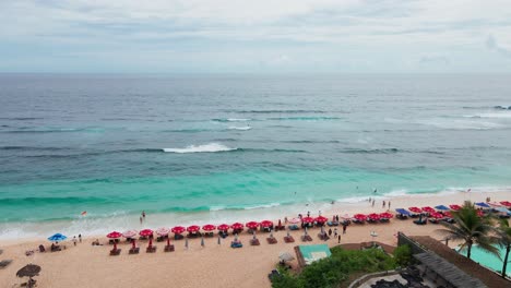 Famous-Melasti-Beach-with-white-sand,-sunbeds,-turquoise-ocean-Bali-Uluwatu