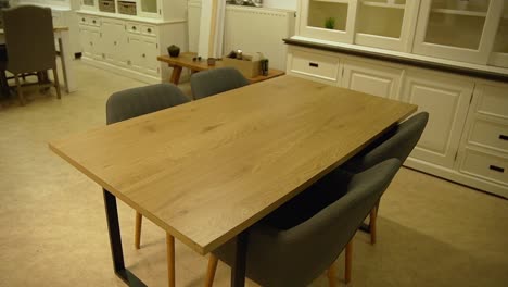 Wooden-table-with-comfortable-grey-chairs-inside-second-hand-furniture-store