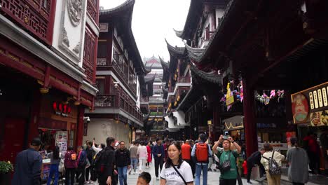 Touristen-Und-Einheimische-Spazieren-Und-Machen-Fotos-In-Einer-Belebten-Fußgängerzone-Mit-Traditioneller-Chinesischer-Architektur