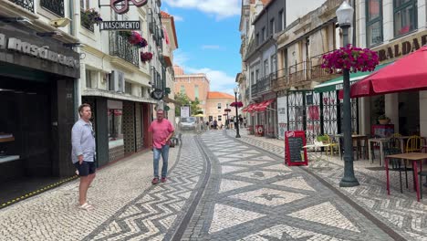 People-walk-on-the-beautiful-pattern-of-the-Portuguese-pavement-in-downtown-Aveiro,-Portugal