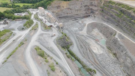 Luftaufnahme-Eines-Großen-Muldenkippers,-Der-Frisch-Abgebautes-Gestein-Aus-Dem-Steinbruch-Anliefert