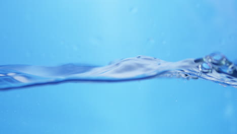 Waves-of-crystal-clear-blue-waters-splashing-and-sputtering-into-tiny-droplets-and-bubbles-of-clean-water