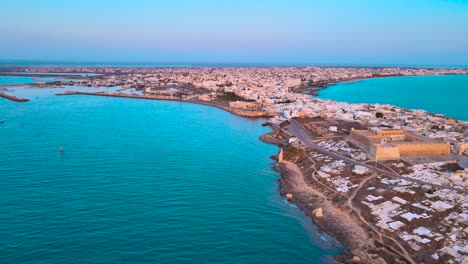 An-aerial-view-of-a-city-of-Mahdia-with-a-large-body-of-water-and-many-buildings