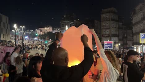 Point-of-view-of-people-lighting-the-fire-and-releasing-the-sky-lanterns-during-the-celebration-in-São-João-do-Porto,-Portugal