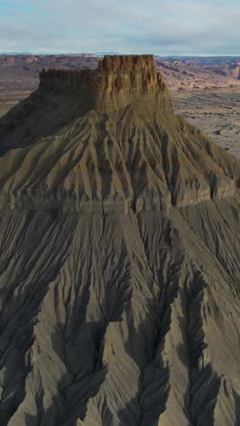 Vista-Aérea-Vertical-De-Un-Paisaje-Lunar,-Tierras-Baldías-De-Arenisca-Gris-Y-Factory-Butte,-Utah,-EE.-UU.