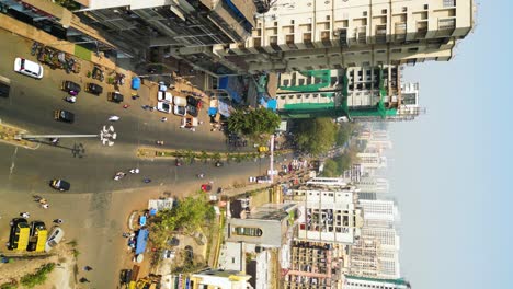 Vertical-aerial-shot-of-Mumbai-traffic,-intersection-with-cars,-bikes,-and-rikshaws,-busy-traffic,-and-Indian-infrastructure