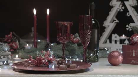 Man-takes-a-chocolate-from-a-decorated-Christmas-table-in-a-dark-room,-close-up-shot