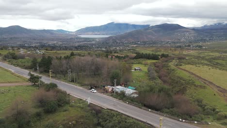 Ariel-shot-road-passing-through-Dique-la-Pueblo-Del-Mollar,-Tucumán,-Tafí-del-Valle,-Argentina