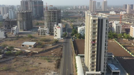 many-vehicles-are-driving-on-the-road-and-many-vehicles-are-surrounded-by-large-buildings