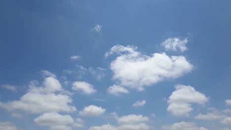 Blue-sky-in-summer-with-cumulus-clouds-moving-past-high-above-the-horizon-in-a-beautiful-motion-time-lapse