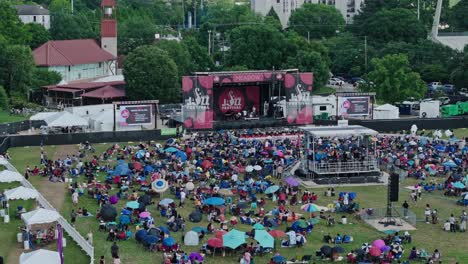 Crowd-of-people-with-umbrella-on-open-air-jazz-festival-in-american-town-during-rainy-day