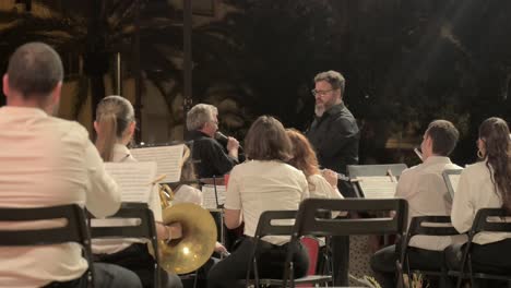 Director-De-Banda-Coordinando-A-Los-Integrantes-De-La-Banda-En-Una-Actuación-Nocturna-En-Sagunto