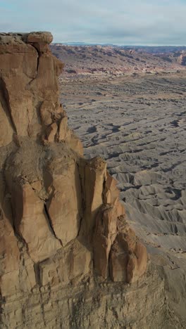 Vista-Aérea-Vertical-De-Patrones-De-Arenisca-Gris-árida-Y-Seca-Y-Paisaje-Desértico-Bajo-Factory-Butte,-Utah,-EE.-UU.