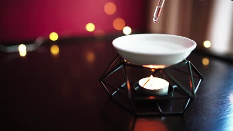 Close-up-of-oil-lamp-with-burning-candle-on-wooden-table