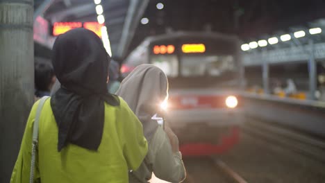 Mujeres-Musulmanas-Indonesias-Con-Hiyabs-Coloridos-Esperando-El-Tren-En-La-Estación-De-Tren-De-Kampung-Bandan-En-El-Norte-De-Yakarta,-Indonesia