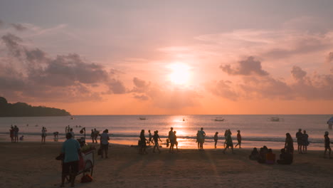 Silhouetted-People-at-Jimbaran-Beach-Near-Sea-Enjoy-Breathtaking-Colorful-Sunset-Over-Water