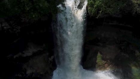 Wide-aerial-shot-in-slow-motion-looking-down-at-the-Minnehaha-waterfall-focusing-on-the-white-water-rushing-down-and-mist-splashing-at-the-base