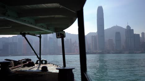 Hermoso-Horizonte-De-La-Megaciudad-De-Hong-Kong-Desde-El-Histórico-Ferry-Star,-Un-Barco-Que-Se-Balancea-Cruzando-El-Tranquilo-Puerto-Del-Mar-De-Victoria-En-Un-Caluroso-Y-Soleado-Día-De-Verano-Con-Cielo-Azul