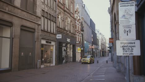 Niederländischer-Sanitätswagen-Fährt-Während-Des-Coronavirus-Ausbruchs-In-Amsterdam,-Niederlande,-Durch-Die-Leere-Einkaufsstraße