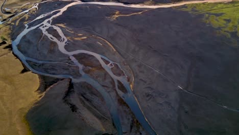 Paisaje-Fluvial-En-El-Ártico-De-Islandia-Con-Hierba-Alpina-Verde-Y-Amarilla-Que-Cubre-El-Suelo-Oscuro