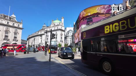 Tourist-buses-and-double-decker-buses-in-Piccadilly-Circus,-London-on-a-sunny-morning