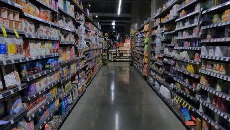 Walking-in-Supermarket-Between-Shelves-With-Cereals-and-Different-Types-of-Food-Supplements