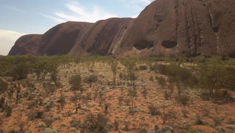 Uluru-Ayres-Rock-Australian-outback,-drone-pull-back-from-the-monolith