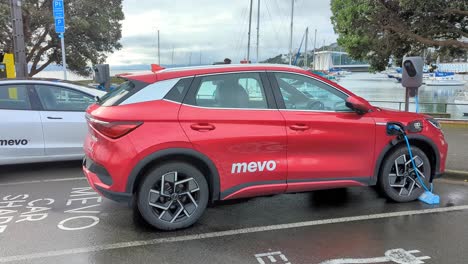 Alquiler-De-Coches-Eléctricos-Mevo-Que-Se-Cargan-En-Un-Aparcamiento-De-La-Ciudad-Capital-De-Wellington,-Nueva-Zelanda,-Aotearoa