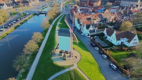 Aerial-orbit-of-the-Kruisvest-mills,-river-and-houses-in-Brugge,-Bruges-Belgium-on-a-beautiful-summer-sunny-evening