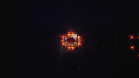 Senior-Couple-Clink-Glasses-on-Romantic-Candlelight-Beach-Dinner,-Drone-Top-Down