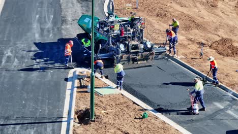 Arbeiter-Schieben-Und-Glätten-Heißes-Bitumen-Hinter-Einer-Straßenfertiger-Auf-Einer-Neuen-Straße-In-Yarrawonga