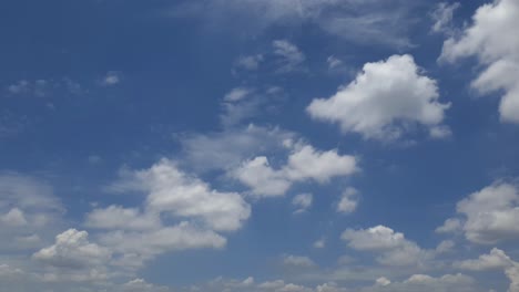 Blue-sky-in-summer-with-cumulus-clouds-moving-past-high-above-the-horizon-in-a-beautiful-motion-time-lapse