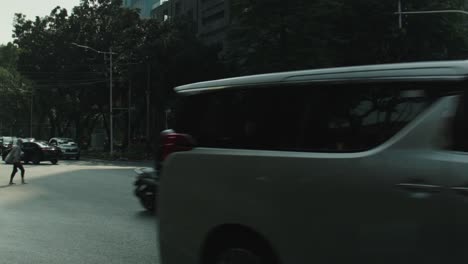 Tower-architecture-of-Jakarta-city-and-the-busy-traffic-with-cars-and-pedestrians-in-Indonesia,-tilt-shot-in-slow-motion