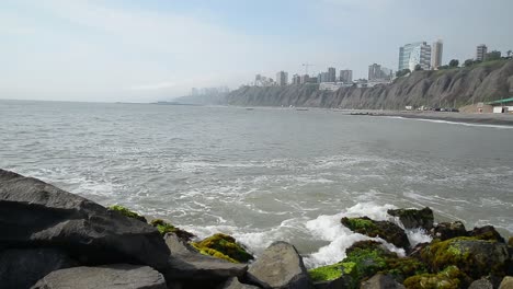 Olas-De-Aguas-Tranquilas-Rompiendo-Suavemente-Contra-Las-Rocas-En-La-Playa-De-La-Costa-Verde---Lima,-Perú