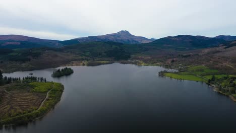 Aerial-shot-over-Loch-Ard-surrounded-by-wooded-rolling-hills