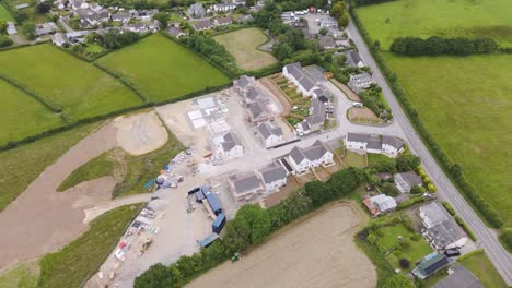 Vista-Aérea-De-Un-Nuevo-Complejo-De-Viviendas-Parcialmente-Construido-En-Una-Zona-Rural-De-Devon,-Reino-Unido,-Que-Muestra-El-Progreso-De-La-Construcción.