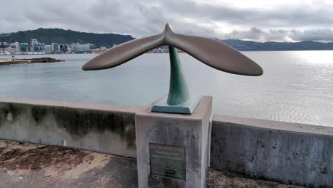 Whale-tail-sculpture-overlooking-Oriental-Bay-beach-and-harbour-in-capital-city-of-Wellington,-New-Zealand-Aotearoa