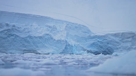 Antarctica-Blue-Glacier-with-Ice-Close-Up-Detail,-Sea-Ice-and-Ocean-Water-Landscape-Scenery,-Low-Angle-Shot-on-Zodiac-Boat-Trip-Tour-in-Beautiful-Antarctic-Peninsula-Cold-Blue-Winter-Scene