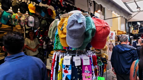 Walking-through-the-old-market-shops-in-Athens,-Greece-as-tourists-buy-souvenirs