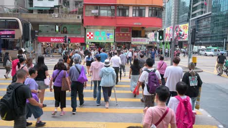 Pedestrians-walk-through-a-busy-and-crowded-zebra-crossing-in-Sham-Shui-Po-district,-Hong-Kong