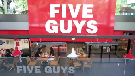 Customers-are-seen-eating-at-the-American-fast-casual-hamburger-restaurant-chain,-Five-Guys,-in-Spain