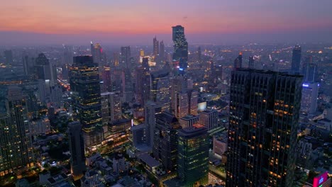 Panorámica-Aérea-Con-Cielo-Al-Atardecer-En-El-Horizonte-Sobre-La-Ciudad-De-Bangkok,-Centro-De-Negocios-En-Tailandia