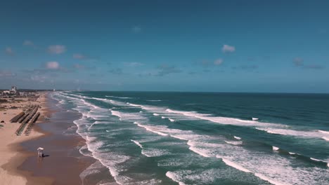 Erleben-Sie-Die-Ruhige-Schönheit-Dieses-Unberührten-Strandes,-Wo-Sanfte-Wellen-Den-Goldenen-Sand-Unter-Einem-Klaren-Blauen-Himmel-Küssen