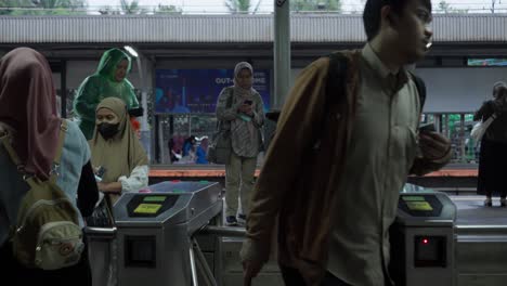 Pasajeros-En-La-Puerta-Tocando-La-Tarjeta-En-La-Estación-De-Tren-Swamp-Untu-En-South-Tangerang-En-Banten,-Indonesia